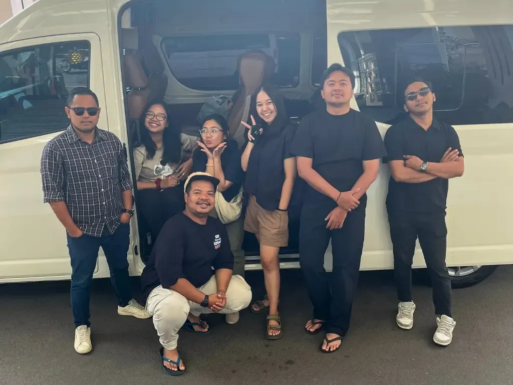 Rombongan berfoto di depan HiAce Nusa Indah Transport sebelum perjalanan wisata
