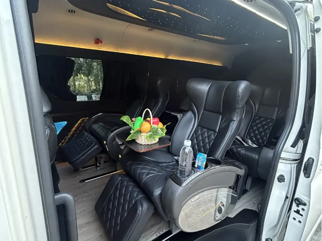 Interior of a HiAce Luxury with captain seats and ceiling TV